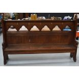 A 19th century oak church pew with carved boards to the sides,