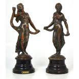 Two late 19th century bronzed metal figurines of classical scantily clad maidens on an ebonised