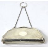 A George V hallmarked silver engine turned purse with chain handle, three compartments to interior,