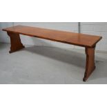 A pitch pine refectory table on slab supports,