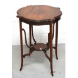 A rosewood occasional table with shaped top and lower tier on outstretched tapering legs,