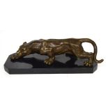 A hot cast bronze on a marble base of a stalking puma/lioness, 41 x 14cm.