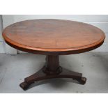 A 19th century walnut loo table on carved baluster base and quatrefoil supports,