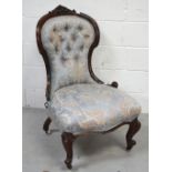 A Victorian overstuffed low chair with shell frame on cabriole legs terminating in castors.