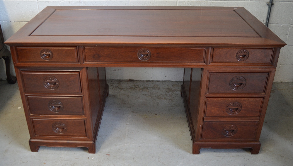 A Chinese hardwood nine drawer pedestal desk, width of top 152cm.