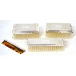 A cased George VI gentleman's toiletry set consisting of three engine turned brushes and a comb,