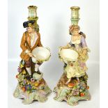 A pair of 19th century continental porcelain figural candlesticks modelled as a gentleman and a