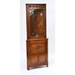 A reproduction Jaycee freestanding oak corner cupboard with leaded glazed upper section and carved