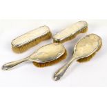 A George V hallmarked silver backed four piece dressing table set comprising two hand brushes with