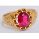 An 18ct yellow gold dress ring, the oval pink claw set stone set within engraved shoulders, size Q,