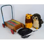 A Tri-ang baby walker containing wooden bricks in four colours, with red wheels, a large toy owl,