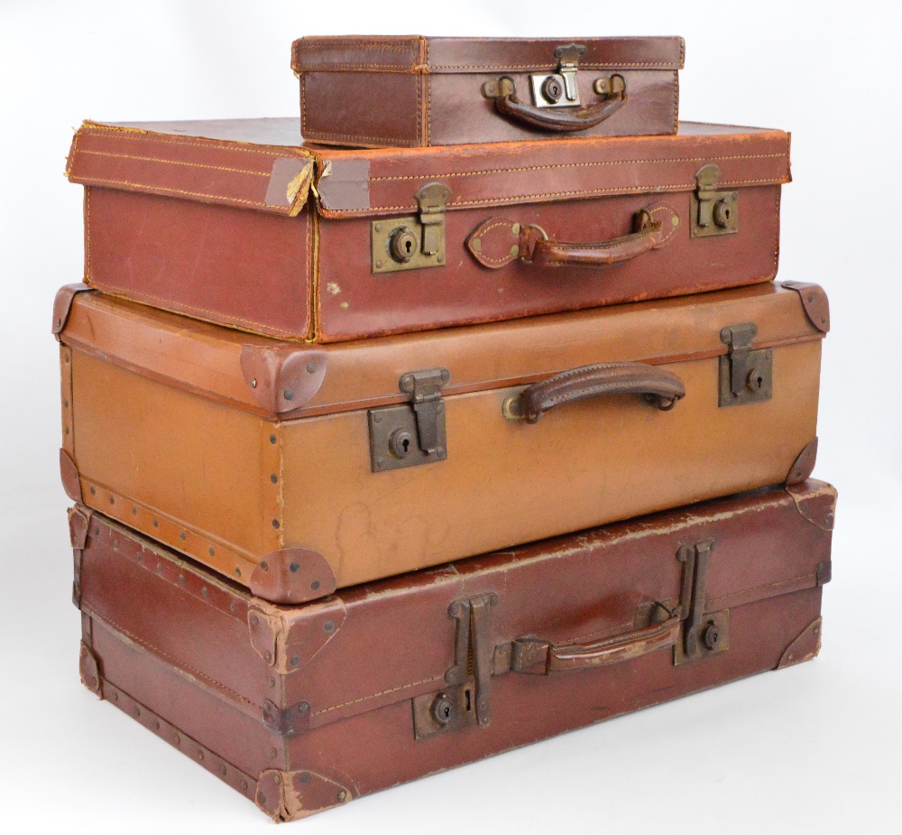 A small collection of vintage suitcases, two faux leather and one leather covered,