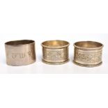 A pair of George V hallmarked silver circular napkin rings with engraved ornamental band,