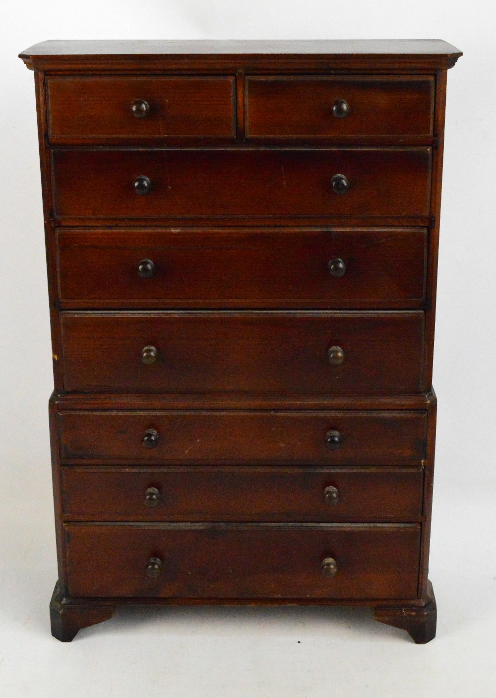 A 20th century miniature stained pine chest on chest raised on bracket feet, height 62.5cm.