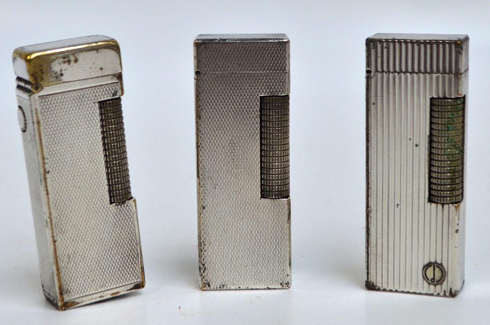 Three engine turned decorated chromed Dunhill lighters.