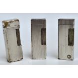 Three engine turned decorated chromed Dunhill lighters.