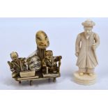 A Japanese Meiji period ivory okimono depicting two seated figures beside a mask, length 6cm,