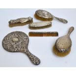 Six variously hallmarked silver backed dressing table items including a circular hand mirror with