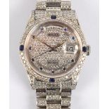 ROLEX; an 18ct white gold day/date wristwatch with diamonds and sapphires set throughout,