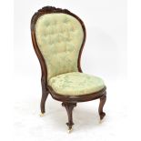 A Victorian rosewood framed and button upholstered nursing chair raised on cabriole front legs to