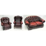 A Chesterfield style three piece ox blood button upholstered leather suite comprising two-seater