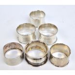 A group of six English variously hallmarked silver napkin rings including a plain circular example