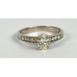 An 18ct white gold diamond ring, the principal oval cut stone weighing approx 0.