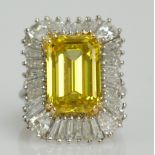 A white metal diamond ring, the central fancy yellow emerald cut stone weighing approx 9.