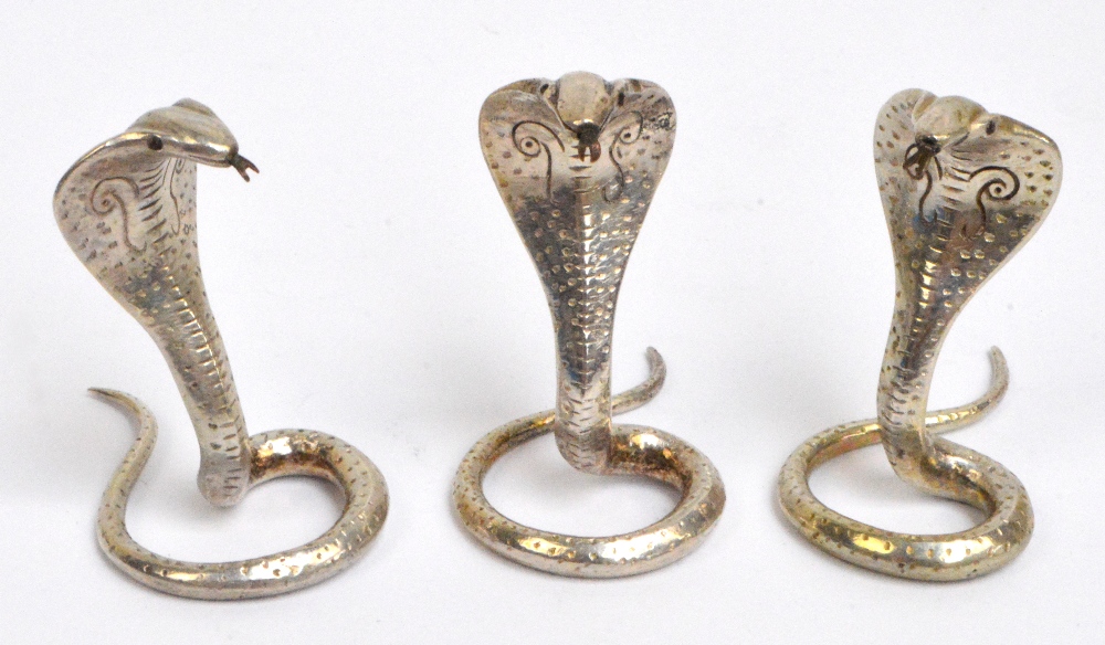 A set of three Ceylonese menu holders modelled as cobras, hallmarked for Kandy, height 4.