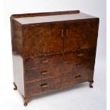 A 1940s walnut side cabinet with two doors above two short and two long drawers on squat cabriole