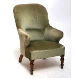 A Victorian armchair with mahogany turned legs to peg feet on glider with velour upholstery.