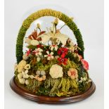 A late 19th century woolwork floral diorama with individual flowers on a grassy base,