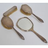 A George V hallmarked silver backed four piece dressing table set comprising a hand mirror with