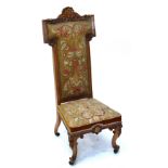 A Victorian walnut framed nursing chair with padded back and seats and carved cabriole front legs.