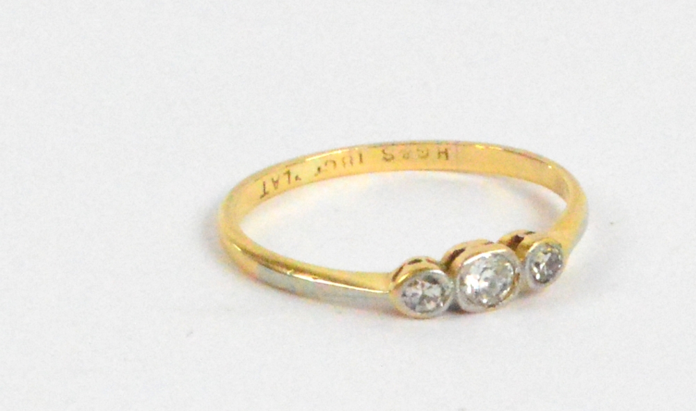 An 18ct yellow gold and tiny diamond three stone ring, size N, approx 1.5g.
