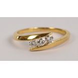 A 9ct yellow gold three stone diamond ring in abstract sweeping mount, size M, approx 2g.