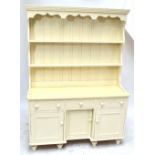A painted pine dresser, the plate rack above three drawers and three doors, width 133cm.