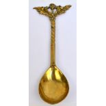 A 19th century Scottish brass spoon with cast thistle decorated finial, length 21cm.