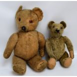 An early 20th century straw filled teddy bear with button eyes,