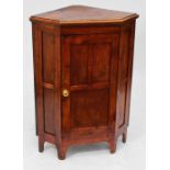A stained pine corner cupboard with single panel door, height 107.5cm.