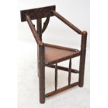 A Victorian oak turner's chair with triangular seat and ring turned front legs.