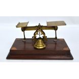 A set of brass Edwardian postal scales with starburst inlaid corners of the wooden rectangular base,