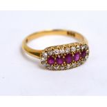 An 18ct yellow gold dress ring with five graduated oval rubies surrounded by twenty small diamonds,