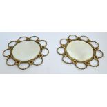 A pair of 1920s brass rope twist open work framed circular bevelled mirrors with floral motifs,