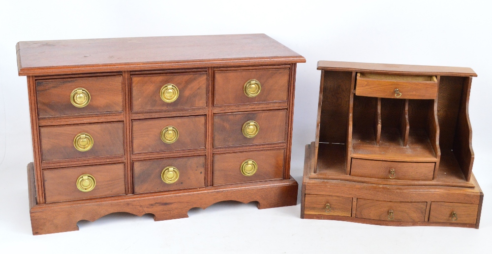 A reproduction mahogany miniature chest of nine short drawers raised on a plinth base, width 58cm,