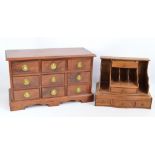 A reproduction mahogany miniature chest of nine short drawers raised on a plinth base, width 58cm,
