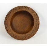 A large Indian carved teak circular bowl with pierced floral rim,