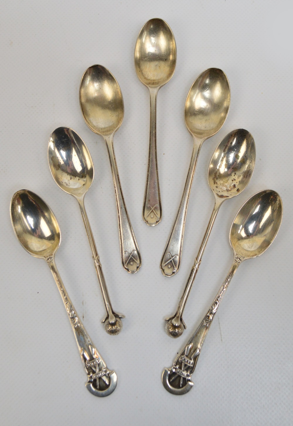 A pair of George V hallmarked silver coffee spoons with stems modelled as three golf clubs and with