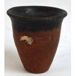 A predynastic Egyptian Badrian beaker of tapering form, bearing a paper lable inscribed "from coll.