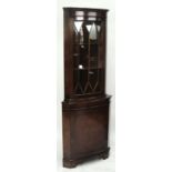 A reproduction walnut freestanding corner cupboard.